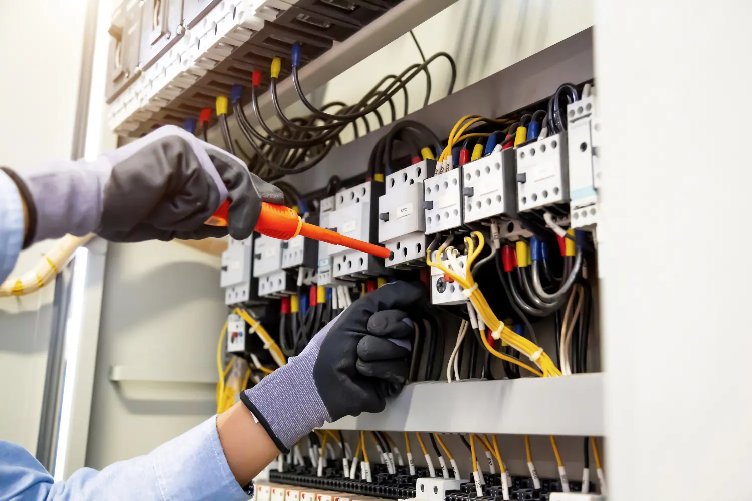 electrician working on an electrical control system panel